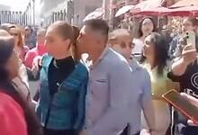 A drunk man leans on Mexican President Claudia Sheinbaum