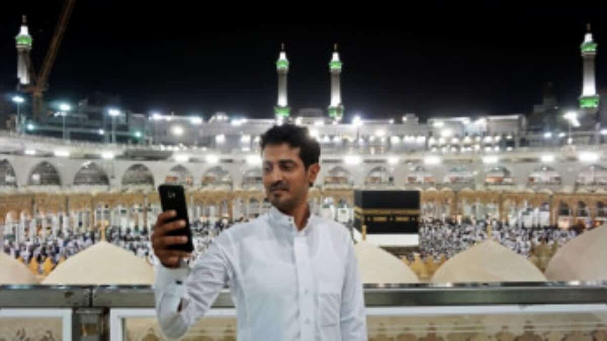 Man taking a photo on his phone at the Grand Mosque in Makkah.