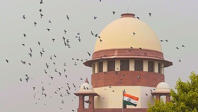 Indian Supreme Court building with flying birds, symbolising justice and freedom.
