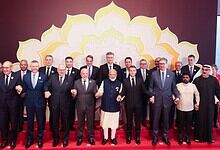 Group of international leaders and officials at the AI Impact Summit signing declaration, promoting globa.