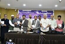 A group of diverse individuals holding books during a book launch event on inner healing.