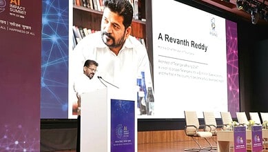 Revanth Reddy speaking at Siasat Daily event with presentation slide in background.