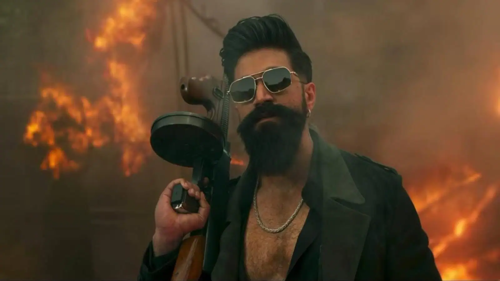Man holding a gun with sunglasses, standing amid a fiery scene.