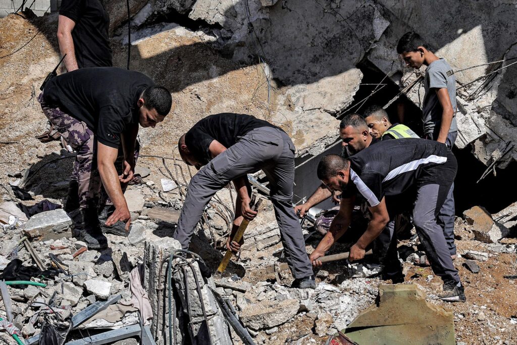 Men search through the rubble of a destroyed building in Gaza following an Israeli air strike.