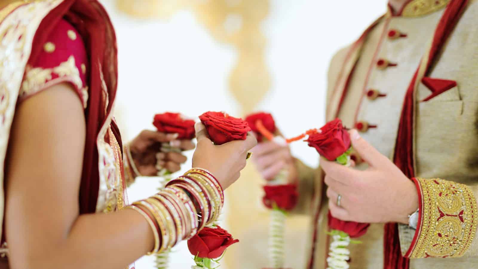 Close-up of bride and groom exchanging floral garlands during wedding ceremony in Hyderabad.