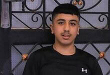 The image of Palestinian teenager Jad Jadallah standing in front of a metal gate.