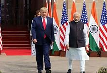 Leaders of India and the US walking past flags during diplomatic discussions.