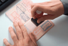 Close-up of a passport being stamped with visa approval.