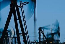 Oil pump jacks at work in an oilfield during daytime.