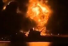 Oil tanker on fire after attack at sea, with large flames and thick black smoke rising.