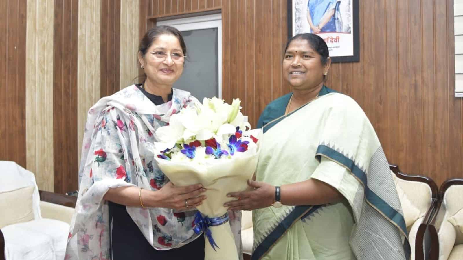 Telangana minister Seethakka with a woman holding a bouquet, advocating for higher wages for crèche worke.