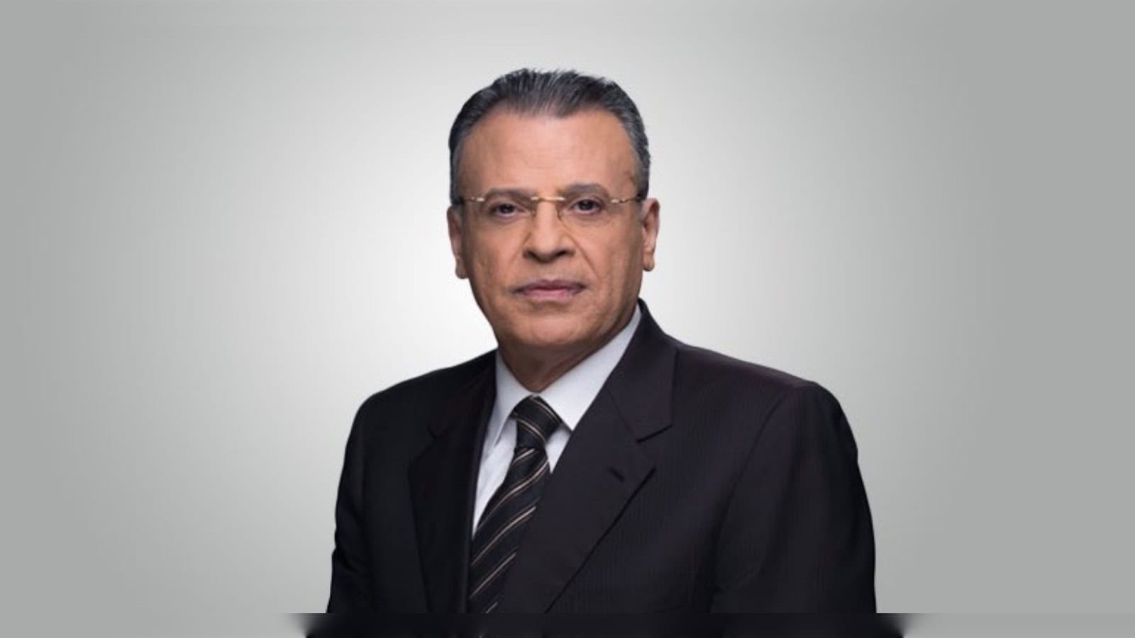 Jamal Rayyan, veteran Al Jazeera journalist, in a formal portrait wearing a suit and tie.