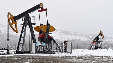 Oil pumpjacks in snowy conditions, extracting oil in cold weather.