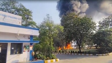 Fire at industrial site with thick black smoke and flames, emergency response required.