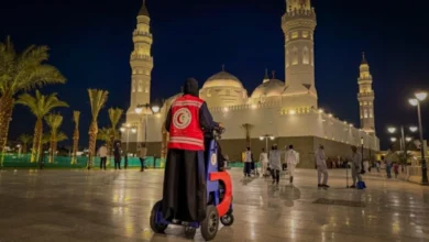 Saudi Red Crescent responder at Quba Mosque in Madinah at night.