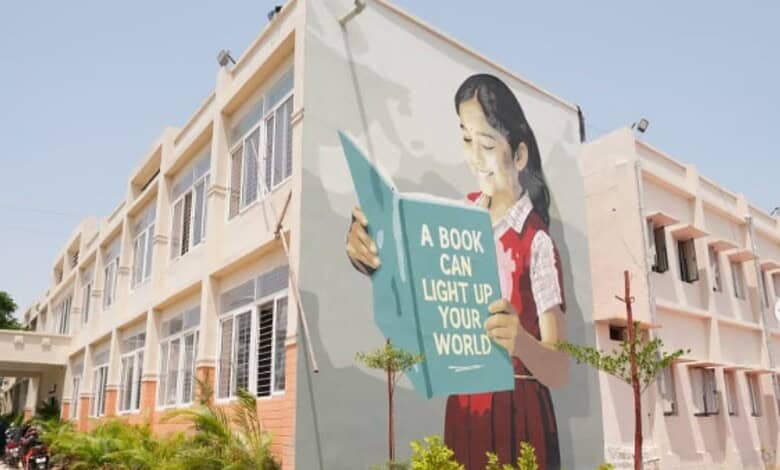 Colorful mural of a girl reading a book on the school wall, promoting education and literacy.