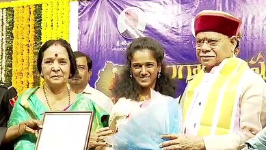 Celebrating an award ceremony with distinguished guests and a woman receiving a certificate in front of a.