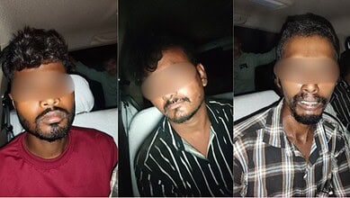 Three men with blurred faces sitting in a vehicle, wearing casual shirts.