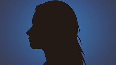 Silhouette of a woman with long hair against a blue background.