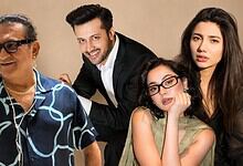 Four diverse individuals smiling and posing together in a studio setting.