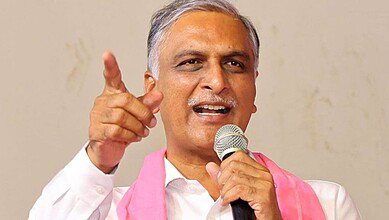 Harish Rao addressing a crowd with a microphone, gesturing with his hand.