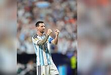 Lionel Messi celebrating on the football field in his Argentina national team jersey.