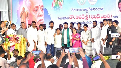 Revanth addresses Telangana youth at a political event with a large crowd and a colourful backdrop.