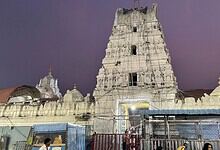 Ancient Dakshina Kashi temple under renovation with scaffolding and construction site.