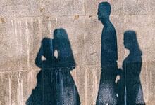 Silhouettes of three girls walking on a wall in Nagpur, India, during daytime.
