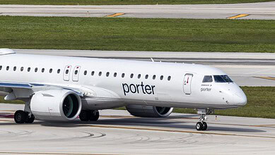 Porter Airlines aircraft on runway with green grass in background.