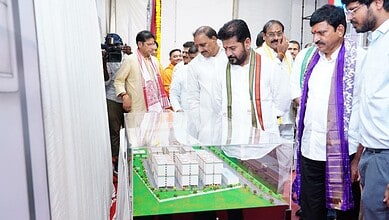 Group of officials examining a detailed architectural model at an event.
