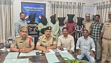 Seven individuals detained by police, with some suspects masked, in a police station in Hyderabad.