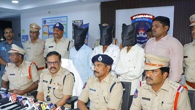 Police officers and suspects with covered faces during a press conference in Hyderabad.