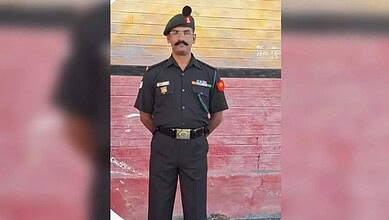 Police officer in uniform standing against a colorful wall in Malkajgiri.