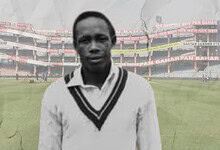 Cricketer in cricket stadium with empty stands, black and white image.