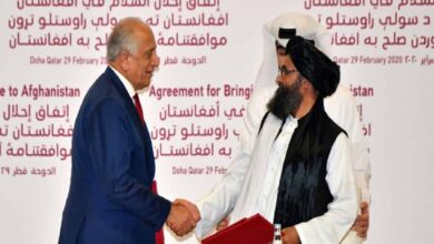 US negotiator Zalmay Khalilzad shakes hands with Taliban co-founder Mullah Baradar after signing the landmark deal