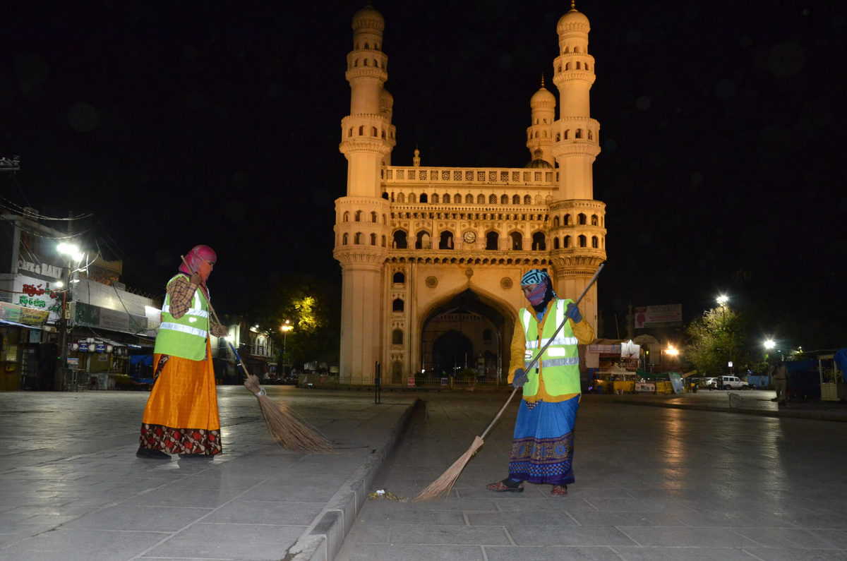 GHMC sanitation staff cleaning the deserted footpath near Charminar during lockdown in Hyderabad. Photo: Mohammed Hussain