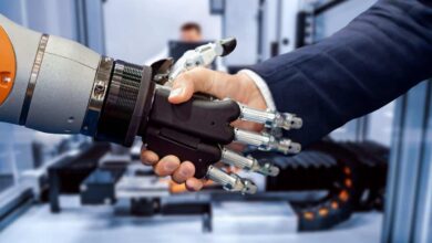 Hand of a businessman shaking hands with a Android robot.
