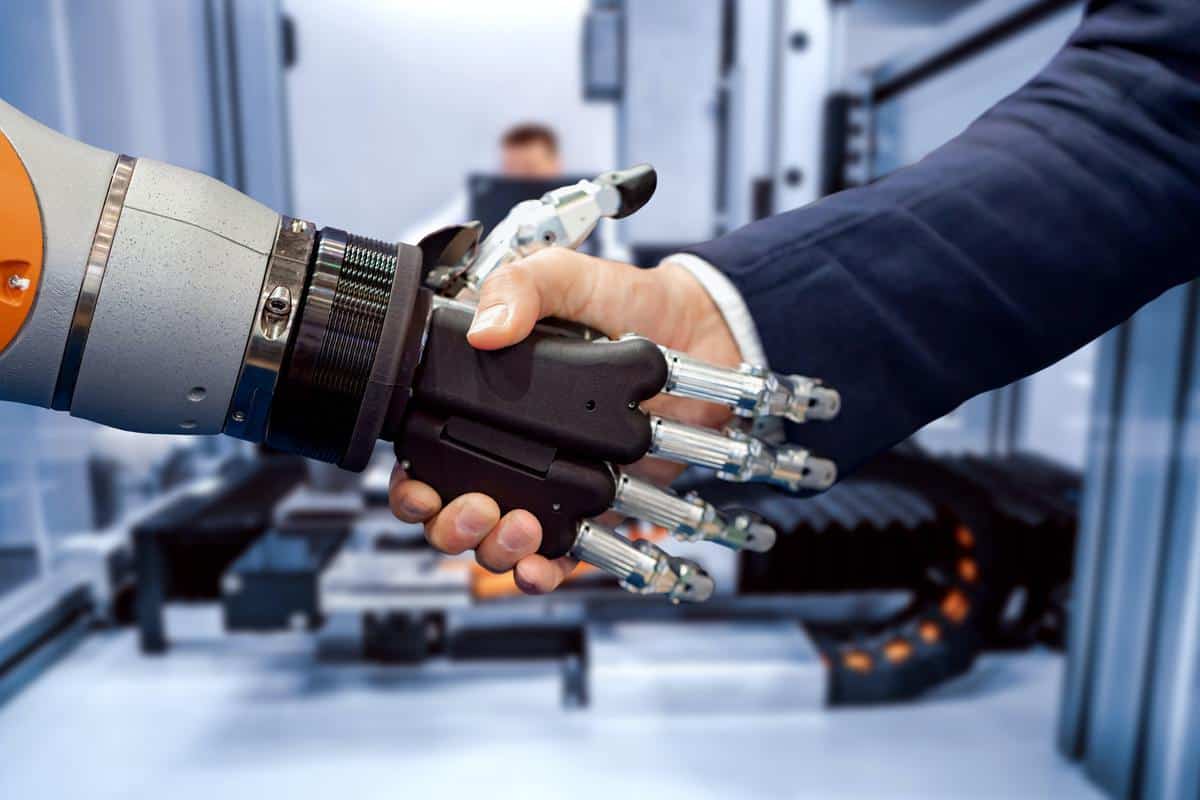 Hand of a businessman shaking hands with a Android robot.
