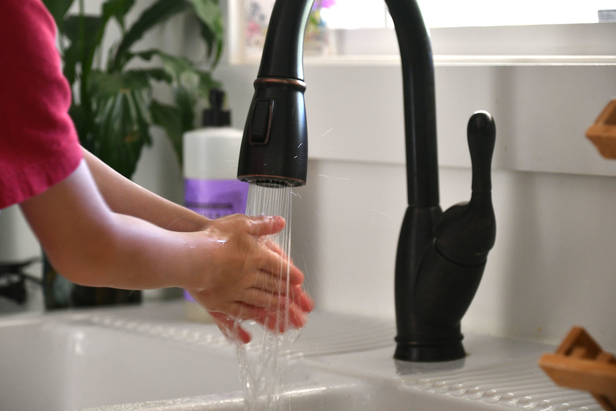 A young boy washing his hands in the kitchen sink before eating. Cleanliness is next to godliness! W