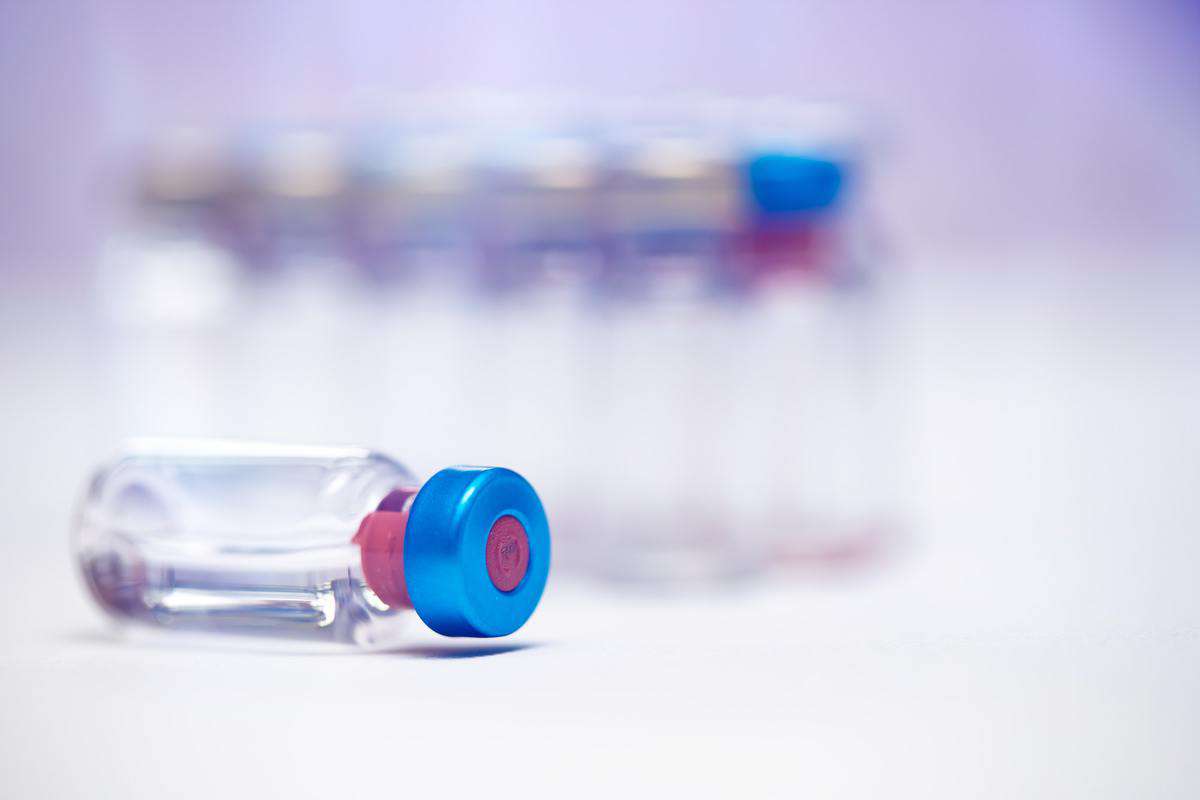 Close up on vaccine and medical syringe