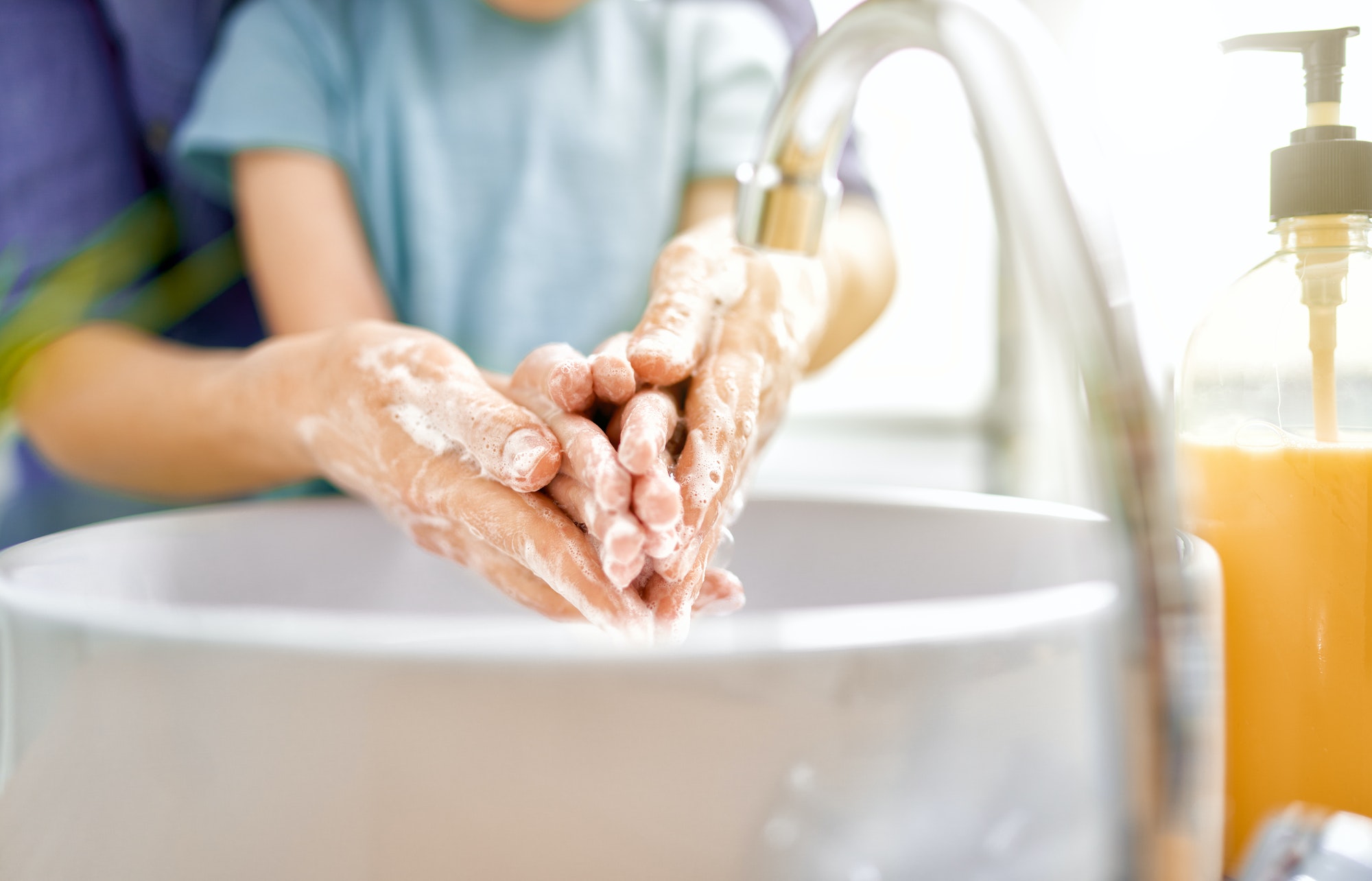 Kid and adult are washing their hands