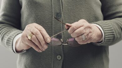 Senior lady hands holding glasses