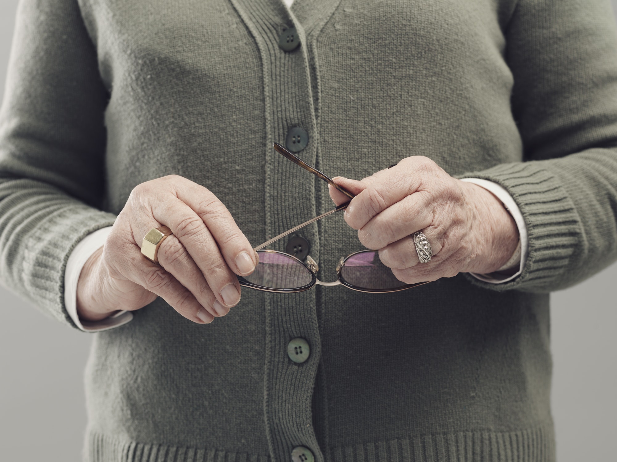 Senior lady hands holding glasses