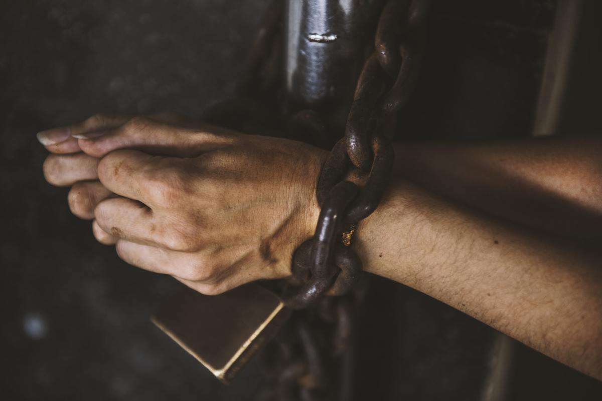Two Hands got Chained with Padlock on Bars Prisoner