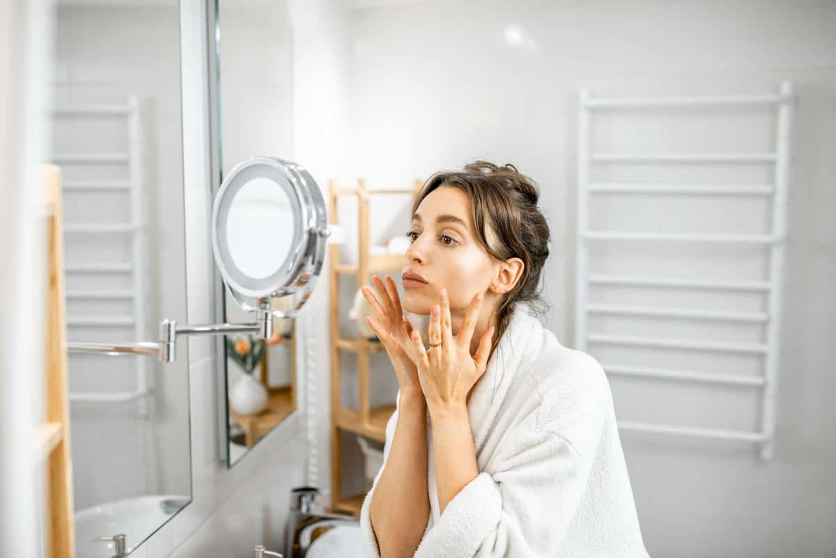 Woman looking on her skin at bathroom