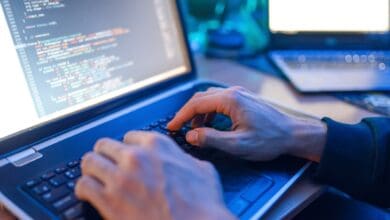 Hacker sitting at laptop, information hacking
