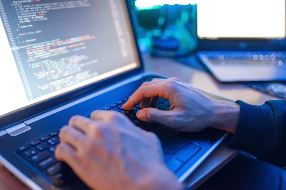 Hacker sitting at laptop, information hacking