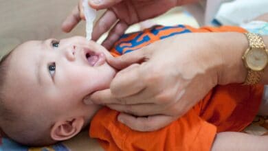 An oral vaccination of a baby boy in a clinic