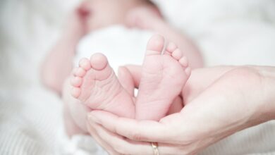 close up of hands holding baby feet
